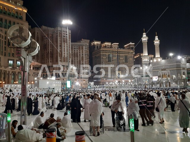A group of pilgrims in the Grand Mosque in Mecca at night, performing Hajj and Umrah rituals, places and landmarks of the holy Islamic religion in the Kingdom of Saudi Arabia, worship and drawing closer to God