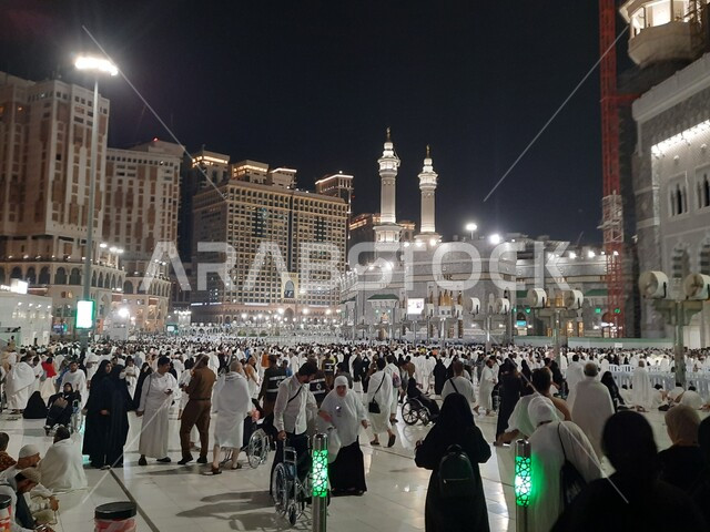 The concept of worship and drawing closer to God, sacred Islamic religious places and landmarks, the Grand Mosque in Mecca in the Kingdom of Saudi Arabia, Muslim pilgrims in the courtyards of the Grand Mosque at night performing the Hajj rituals