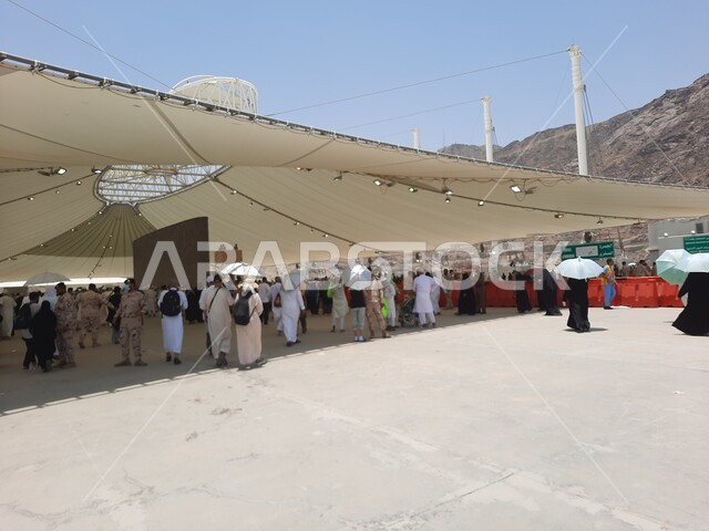 أماكن إسلامية مقدسة, مفهوم العبادة و التقرب من الله تعالى, مجموعة من الحجاج والمعتمرين يقفون تحت الشمسية في منطقة رمي الجمرات في مكة المكرمة, أداء مناسك الحج والعمرة