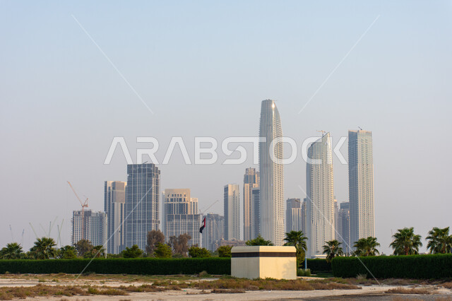 الفن الهندسي المعماري لبناء المنشآت و المباني على الطراز الحديث, التوسع العمراني في الإمارات العربية المتحدة, منظر الأبراج و ناطحات السحاب في منطقة خور بمدينة دبي في النهار، الاهتمام بزراعة الأشجار الخضراء في المدن