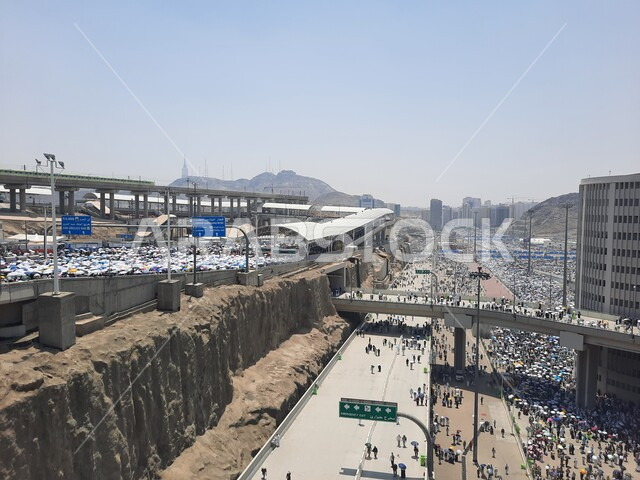 أداء مناسك الحج والعمرة, زيارة بيت الله الحرام, مجموعة من الحجاج يسيرون على جسر الجمرات في مكة المكرمة, أماكن و معالم دينية إسلامية مقدسة في المملكة العربية السعودية