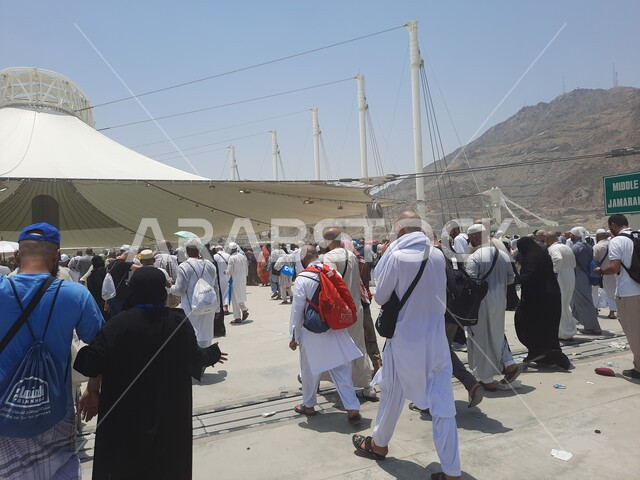 أماكن إسلامية دينية مقدسة, مفهوم العبادة و التقرب من الله تعالى, مجموعة من الحجاج والمعتمرين يسيرون تحت المظلات في منطقة رمي الجمرات في مكة المكرمة, زوار بيت الله الحرام يقومون بأداء مناسك الحج والعمرة