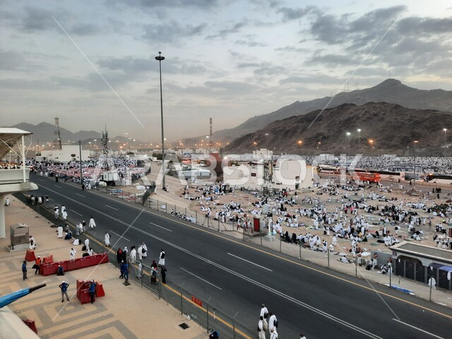 Worshiping and getting closer to God in sacred Islamic religious landmarks and places, pilgrims of the Sacred House of God in Muzdalifah wearing the Ihram dress in Mecca in the Kingdom of Saudi Arabia, performing the rituals of Hajj and Umrah.