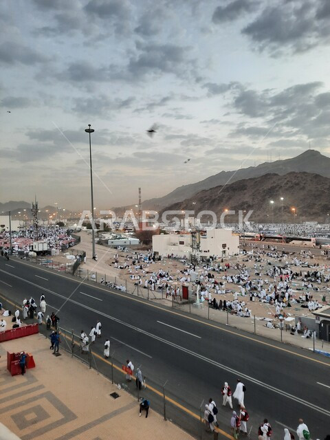 Worshiping and getting closer to God in sacred Islamic religious landmarks and places, pilgrims of the Sacred House of God in Muzdalifah wearing the Ihram dress in Mecca in the Kingdom of Saudi Arabia, performing the rituals of Hajj and Umrah.