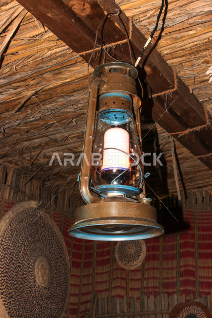 فانوس عربي تقليدي في سوق عكاظ ، فانوس معلق على سقف الحائط  ، مصباح قديم الطراز مصنوعة من النحاس ، شهر رمضان ، فانوس رمضان