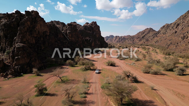 التكوينات والتشكيلات الصخرية في المناطق الصحراوية, التضاريس في القمم والمرتفعات الجبلية, منظر السماء المليئة بالغيوم والسحب البيضاء, مناطق السياحة وقضاء الوقت الممتع, أماكن الرحلات والمغامرات السياحية في الصحاري السعودية