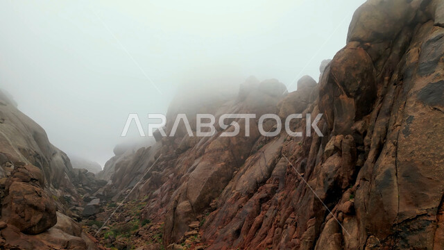 التكوينات والتشكيلات الصخرية في المناطق الصحراوية, التضاريس في القمم والمرتفعات الجبلية, منظر السماء المليئة بالغيوم والسحب البيضاء, مناطق السياحة وقضاء الوقت الممتع, أماكن الرحلات والمغامرات السياحية في الصحاري السعودية