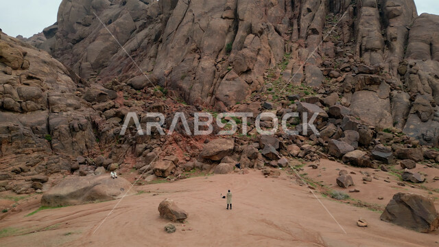 Rock formations and formations in desert areas, terrain in mountain peaks and heights, view of the sky full of clouds and white clouds, areas for tourism and spending enjoyable time, places for tourist trips and adventures in the Saudi deserts