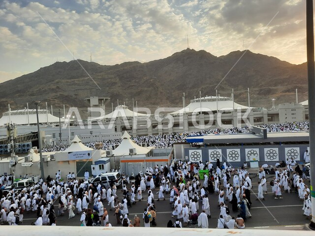 اداء مناسك الحج والعمرة في وقت غروب الشمس، حجاج بيت الله الحرام في مزدلفة يرتدون لباس الإحرام في مكة المكرمة في المملكة العربيه السعودية,  العبادة والتقرب إلى الله في معالم واماكن اسلامية دينية مقدسة