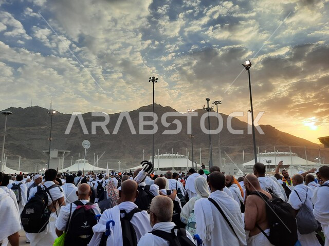 حجاج بيت الله الحرام في مزدلفة يرتدون لباس الإحرام في مكة المكرمة في المملكة العربيه السعودية,  العبادة والتقرب إلى الله في معالم واماكن اسلامية دينية مقدسة، اداء مناسك الحج والعمرة في وقت غروب الشمس