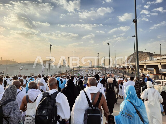 مجموعة من الحجاج يسيرون على جسر الجمرات بمكة المكرمة، أداء مناسك الحج والعمرة, أماكن و معالم دينية إسلامية مقدسة في المملكة العربية السعودية, زيارة بيت الله الحرام في وقت النهار