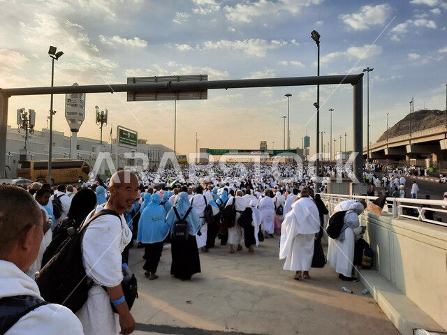 مجموعة من الحجاج يسيرون على جسر الجمرات بمكة المكرمة، أداء مناسك الحج والعمرة, أماكن و معالم دينية إسلامية مقدسة في المملكة العربية السعودية, زيارة بيت الله الحرام في وقت النهار