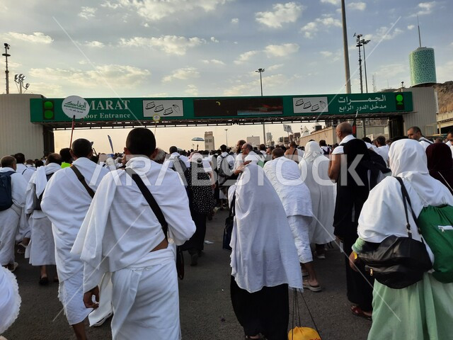 مجموعة من الحجاج يسيرون على جسر الجمرات بمكة المكرمة، أداء مناسك الحج والعمرة, أماكن و معالم دينية إسلامية مقدسة في المملكة العربية السعودية, زيارة بيت الله الحرام في وقت النهار