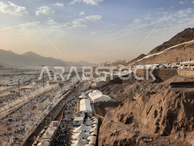 مجموعة من الحجاج يسيرون على جسر الجمرات بمكة المكرمة، أداء مناسك الحج والعمرة, أماكن و معالم دينية إسلامية مقدسة في المملكة العربية السعودية, زيارة بيت الله الحرام في وقت النهار