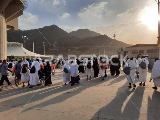 مجموعة من الحجاج يسيرون على جسر الجمرات بمكة المكرمة، أداء مناسك الحج والعمرة, أماكن و معالم دينية إسلامية مقدسة في المملكة العربية السعودية, زيارة بيت الله الحرام في وقت النهار