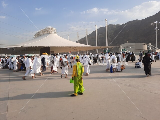 مجموعة من الحجاج يسيرون على جسر الجمرات بمكة المكرمة، أداء مناسك الحج والعمرة, أماكن و معالم دينية إسلامية مقدسة في المملكة العربية السعودية, زيارة بيت الله الحرام في وقت النهار