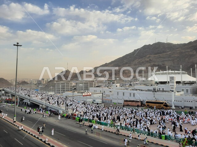 A group of pilgrims walk on the Jamarat Bridge in Mecca, performing Hajj and Umrah rituals, sacred Islamic religious places and landmarks in the Kingdom of Saudi Arabia, visiting the Holy House of God during the day
