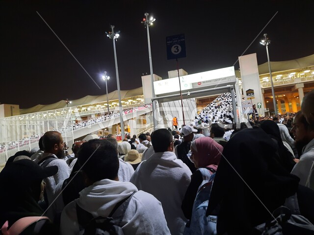 مجموعة من الحجاج يسيرون على جسر الجمرات بمكة المكرمة، أداء مناسك الحج والعمرة, أماكن و معالم دينية إسلامية مقدسة في المملكة العربية السعودية, زيارة بيت الله الحرام في وقت الليل