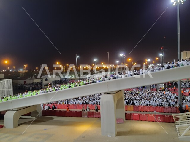 مجموعة من الحجاج يسيرون على جسر الجمرات بمكة المكرمة، أداء مناسك الحج والعمرة, أماكن و معالم دينية إسلامية مقدسة في المملكة العربية السعودية, زيارة بيت الله الحرام في وقت الليل