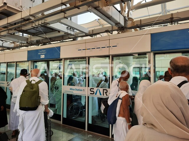 صورة لحجاج بيت الله الحرام بملابس الإحرام البيضاء يتنقلون عبر قطار الحرمين السريع في مكة المكرمة ، محطة الرصيفة في مكة المكرمة ، خدمات نقل الحجاج للمسجد الحرام ، خدمات نقل آمنة و مريحة في موسم الحج