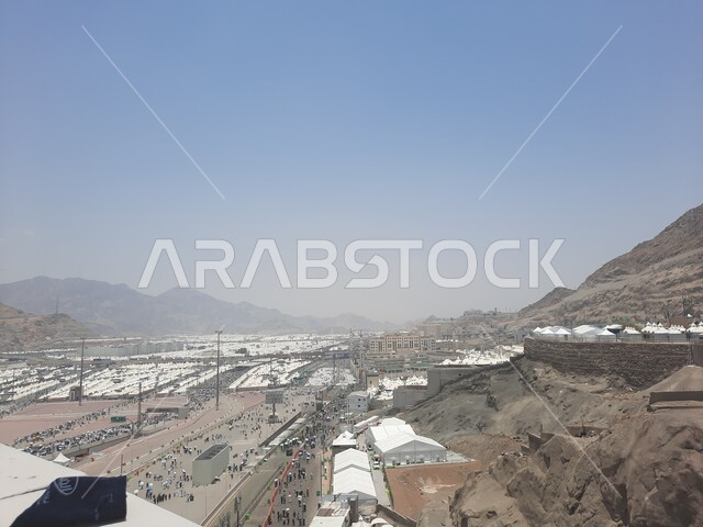 زوار بيت الله الحرام يسيرون في منطقة جسر الجمرات في مكة المكرمة و يحملون المظلات, أماكن إسلامية دينية مقدسة في المملكة العربية السعودية, العبادة و التقرب إلى الله تعالى, الحجاج المسلمين يقومون بأداء مناسك الحج والعمرة