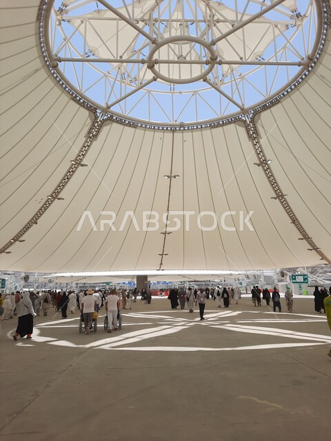 Group view of a group of pilgrims walking on the Jamarat Bridge in Mecca, the concept of worship and drawing closer to God, performing the Hajj and Umrah rituals, sacred Islamic religious places and landmarks in the Kingdom of Saudi Arabia, visiting the Holy House of God