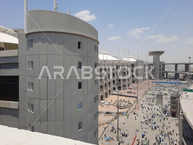 منظر جماعي لمجموعة من الحجاج يسيرون على جسر الجمرات بمكة المكرمة، مفهوم العبادة والتقرب إلى الله، أداء مناسك الحج والعمرة, أماكن و معالم دينية إسلامية مقدسة في المملكة العربية السعودية, زيارة بيت الله الحرام