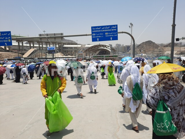 خدمات نقل آمنة و مريحة في موسم الحج، صورة مقربة لحجاج بيت الله الحرام بملابس الإحرام البيضاء يقفون ينتظرون قطار الحرمين السريع في مكة المكرمة بعد رمي الجمرات ، محطة الرصيفة في مكة المكرمة ، وسائل نقل الحجاج للمسجد الحرام