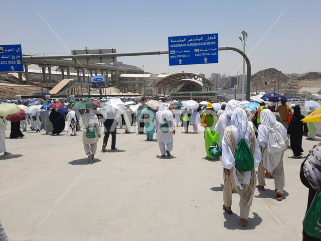خدمات نقل آمنة و مريحة في موسم الحج، صورة مقربة لحجاج بيت الله الحرام بملابس الإحرام البيضاء يقفون ينتظرون قطار الحرمين السريع في مكة المكرمة بعد رمي الجمرات ، محطة الرصيفة في مكة المكرمة ، وسائل نقل الحجاج للمسجد الحرام