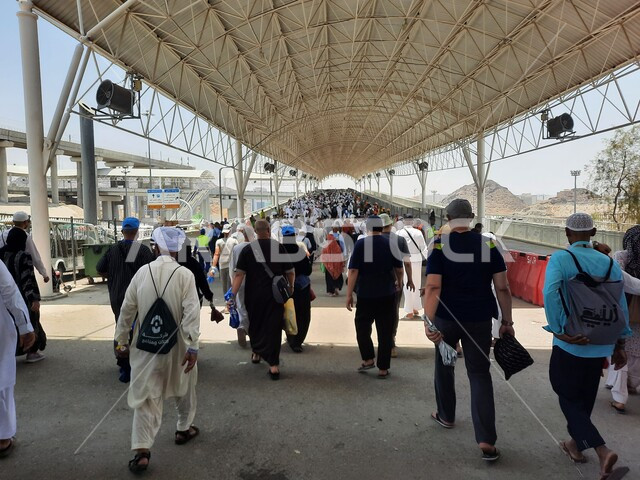 خدمات نقل آمنة و مريحة في موسم الحج، صورة مقربة لحجاج بيت الله الحرام بملابس الإحرام البيضاء يقفون ينتظرون قطار الحرمين السريع في مكة المكرمة بعد رمي الجمرات ، محطة الرصيفة في مكة المكرمة ، وسائل نقل الحجاج للمسجد الحرام