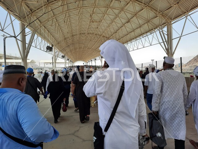 خدمات نقل آمنة و مريحة في موسم الحج، صورة مقربة لحجاج بيت الله الحرام بملابس الإحرام البيضاء يقفون ينتظرون قطار الحرمين السريع في مكة المكرمة بعد رمي الجمرات ، محطة الرصيفة في مكة المكرمة ، وسائل نقل الحجاج للمسجد الحرام