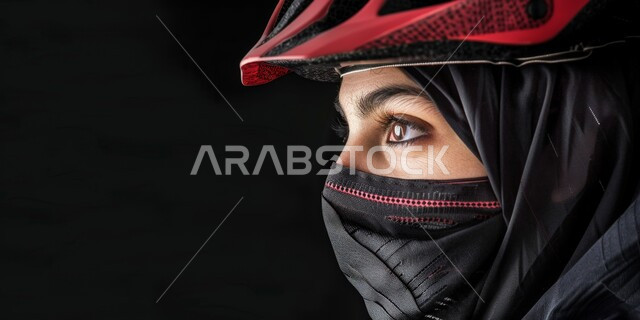 أنشطة بدنية متنوعة، فعاليات وسباقات الدراجات، بورتريه مقرب لشابة عربية خليجية سعودية ملثمة ترتدي حجاب أسود وخوذة الحماية الخاصة بركوب الدراجة الهوائية، المحافظة على الصحة واللياقة الجسدية، خلفية سوداء
