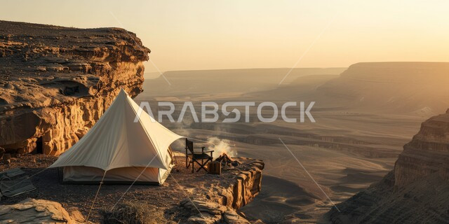 A youth camp and desert session, spending enjoyable times camping in the deserts of the Kingdom of Saudi Arabia, a popular Bedouin tent in the middle of the desert overlooking a valley, rocky terrain and soft golden sand, tourist camps in the wilderness areas