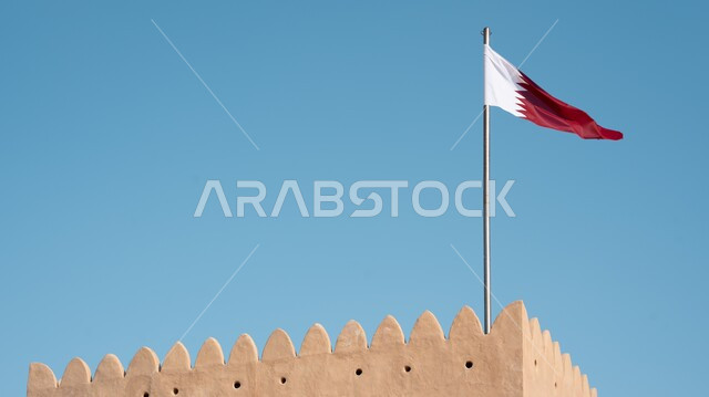 أعلام الدول العربية, صورة مقربة لعلم دولة قطر معلق يرفرف في السماء, الرموز الوطنية القطرية، اليوم الوطني القطري, مفهوم حب الوطن والانتماء اليه