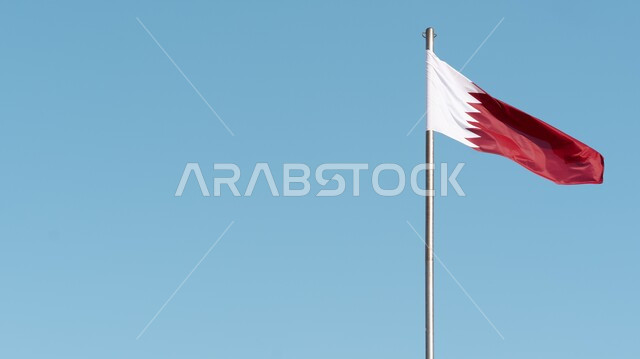 Flags of Arab countries, close-up of the flag of the State of Qatar hanging and waving in the sky, Qatari national symbols, Qatar National Day, the concept of love and belonging to the homeland