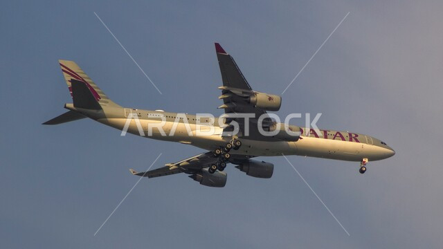 Qatar Airways, plane flying in the sky of Qatar, air transportation, tourism and travel concept, clear blue sky background