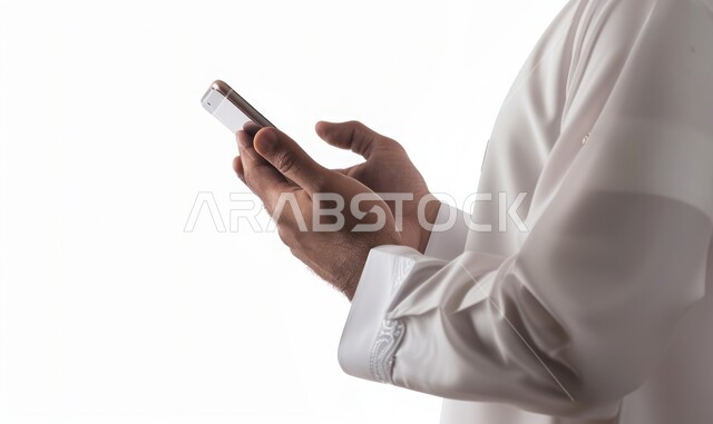 إرسال رسالة نصية عبر الجوال, بورتريه مقرب ليدي رجل عربي خليجي سعودي يرتدي الثوب التقليدي يقوم بمتابعة آخر أخبار السوشال ميديا عبر الهاتف المحمول, التواصل مع الأصدقاء والأقارب ، تصفح موقع الانترنت، دمج التكنولوجيا الحديثة بالحياة العملية، خلفية بيضاء