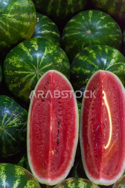 فاكهة البطيخ الأحمر بسوق الخضار والفواكه بمنطقة الديرة بمدينة دبي بالإمارات، خضار وفواكه طازجة، المحاصيل الزراعية والمنتجات المحلية، الفاكهة الموسمية الصيفية الطازجة ، صورة مقربة لحبات وشرائح البطيخ الأحمر الصحي والشهي، الأسواق الشعبية لبيع الخضراوات والفواكه