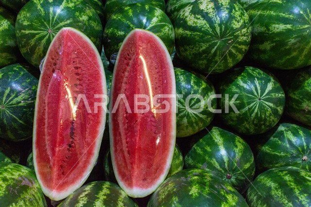 فاكهة البطيخ الأحمر بسوق الخضار والفواكه بمنطقة الديرة بمدينة دبي بالإمارات، خضار وفواكه طازجة، المحاصيل الزراعية والمنتجات المحلية، الفاكهة الموسمية الصيفية الطازجة ، صورة مقربة لحبات وشرائح البطيخ الأحمر الصحي والشهي، الأسواق الشعبية لبيع الخضراوات والفواكه