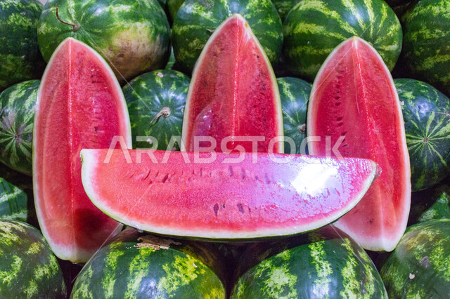 فاكهة البطيخ الأحمر بسوق الخضار والفواكه بمنطقة الديرة بمدينة دبي بالإمارات، خضار وفواكه طازجة، المحاصيل الزراعية والمنتجات المحلية، الفاكهة الموسمية الصيفية الطازجة ، صورة مقربة لحبات وشرائح البطيخ الأحمر الصحي والشهي، الأسواق الشعبية لبيع الخضراوات والفواكه