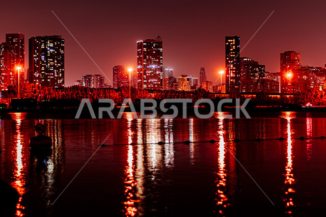 Attractions and tourist attractions, the reflection of lights and lights of hotels and buildings on the sea water at night, the architectural art of building towers and skyscrapers on Al Mamzar Beach, the coastal waterfront in Dubai, urban growth and development in the United Arab Emirates