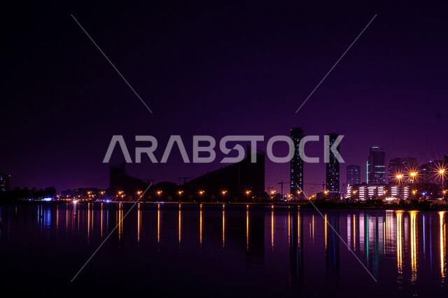 Architectural engineering art in building towers and skyscrapers on Al Mamzar Beach, the coastal waterfront in Dubai, the reflection of lights and lights of hotels and buildings on the sea water at night, urban growth and development in the United Arab Emirates, tourist attractions and attractions