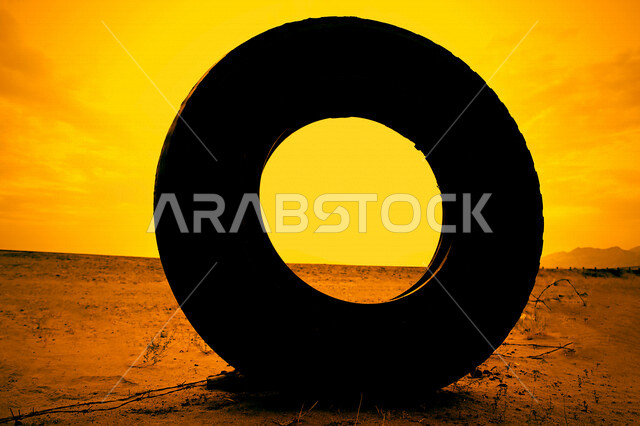 صورة جمالية خلابة لغروب الشمس البرتقالي من خلال أطار دائري  , غروب الشمس الإبداعي من الصحراء, جمال الطبيعة الصحراوية  الخلابة في وقت غروب الشمس