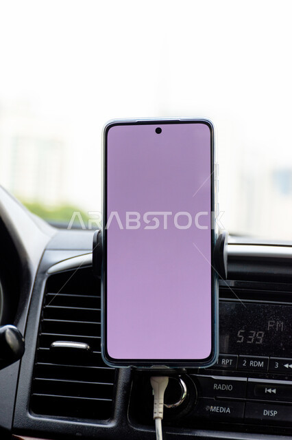 عرض شاشة بيضاء فارغة عبر شاشة الهاتف المحمول داخل سيارة في مدينة الشارقة، استخدام أجهزة التكنولوجيا الحديثة والمتطورة، خدمة توصيل الركاب في الامارات العربية المتحدة