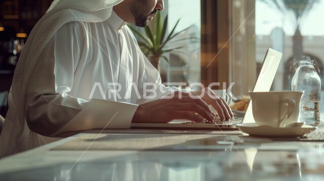 مفهوم إدارة شؤون الأعمال وتنظيمها عبر الاجهزة التقنية، دمج العمل مع التقنية والتكنولوجيا، صورة مقربة ليدي رجل عربي خليجي سعودي يقوم بالعمل على جهاز الحاسوب المحمول داخل المكتب، مهن ووظائف ادارية مكتبية في المملكة العربية السعودية