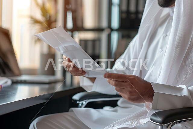مفهوم الدقة والتركيز في انجاز المعاملات، تحقيق الاهداف المالية للشركة، صورة مقربة لرجل أعمال عربي خليجي سعودي يقوم بدراسة الأرباح، جمع بيانات البورصه وسوق الأسهم, دراسة و تحليل الاحصائيات و الرسوم البيانية, دمج التكنولوجيا مع العمل.