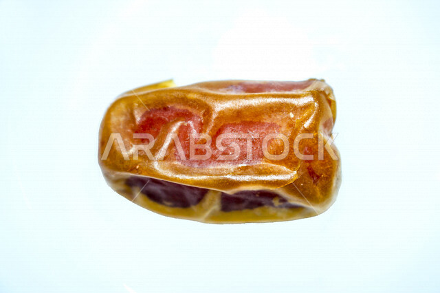 Portrait of one piece of dates full of high nutritional values, summer fruits, fruits of palm trees, white background