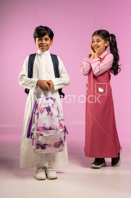 The concept of affection between colleagues, preparing for the new school year, a portrait of a Saudi Arabian Gulf boy wearing traditional dress carrying his colleague's bag as an expression of support and love, full-length body, colored background