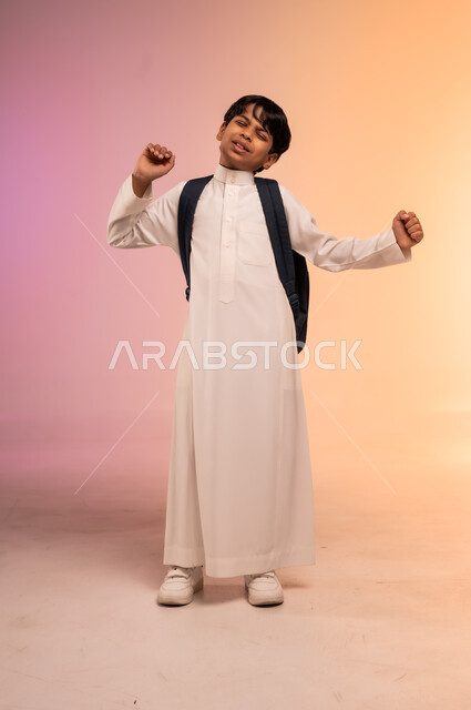  الاستعداد للذهاب إلى المدرسة، بورتريه لطالب عربي خليجي سعودي يرتدي الثوب التقليدي يحمل حقيبة الظهر المدرسية يرفع يديه بإيماءات النعاس والكسل، الحاجة إلى النشاط والتركيز، موسم العودة للمدارس في المملكة العربية السعودية، صورة الجسم بالطول الكامل، خلفية ملونة