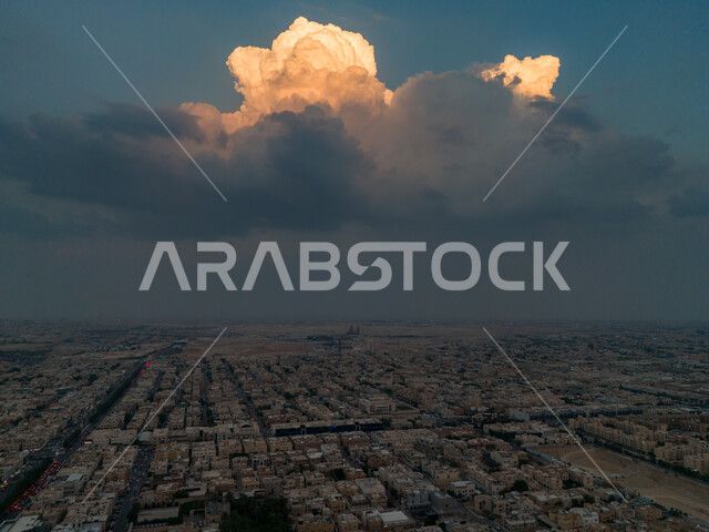 Urban growth and development in Saudi Arabia, aerial drone view of Riyadh city architecture at sunset, towers, skyscrapers, commercial buildings and facilities, urban progress in cities and neighborhoods, background of sky covered with large dense clouds